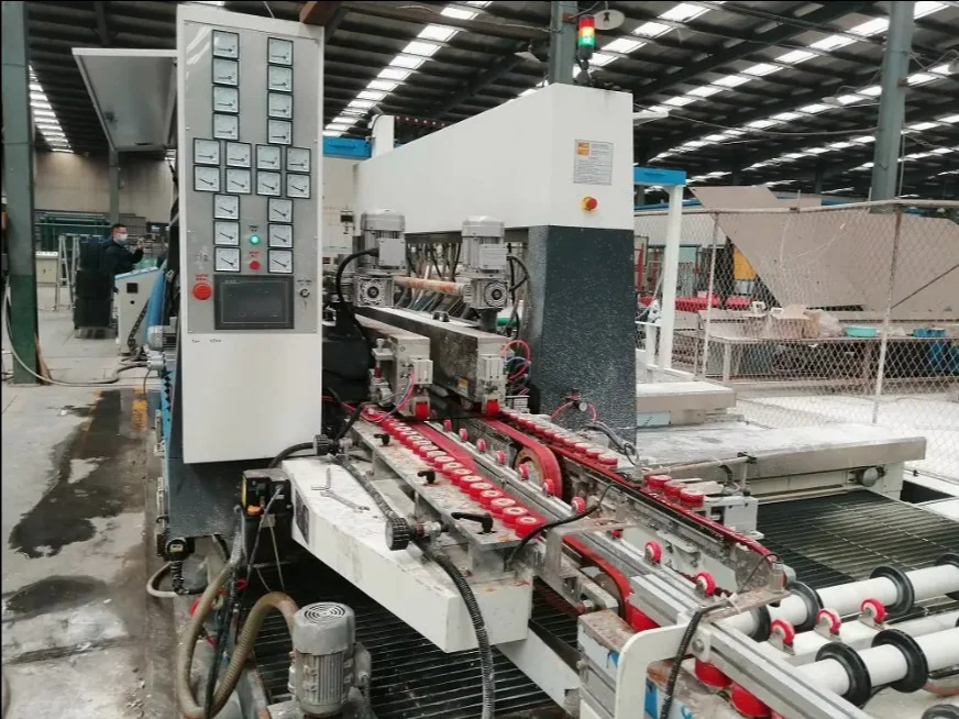 Glass double edging machine processing station in a factory